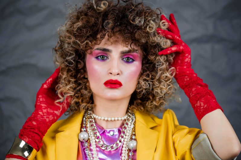 A woman wearing 1980s style fashion and makeup