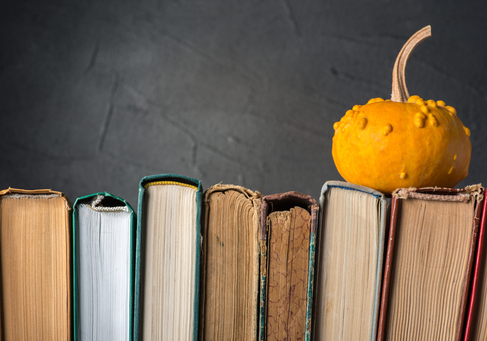 A pumpkin sat atop row of books